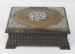 Porta jóias em madeira nobre entalhada, decorada com apliques de flores e folhagens em prata. Parte interna forrada com tecido vermelho. Med. 7x19,5x14,5cm.