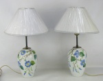 Par de abajours em porcelana Real, com decoração de pintura de flores e folhagens em policromia. Cúpulas em material sintético. Alts. com cúpula 47cm.