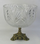 Centro de mesa em cristal da Bohemia, com lapidações em sulcos bisotados e minúsculos frisos em satiné. Base em bronze dourado e trabalhos em folhas, volutas e perolados. Borda ondulada e serrilhada. Med. 22,5x22 cm.