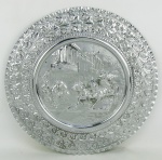 Medalhão em metal espessurado a prata, decorado ao centro, em relevo, com cenas gregas em relevo. Aba com flores e folhagens. Diam. 43 cm.