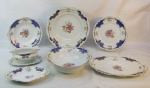 Aparelho de jantar para 6 pessoas em porcelana alemã Bavaria-Winterling, ricamente decorada com pintura floral em policromia, dourado e detalhes na cor azul, sendo travessa, saladeira, molheira, covilhete, legumeira, 6 pratos rasos, 6 fundos e 6 para sobremesa. Total 23 peças.