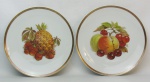 Par de pratos decorativos em porcelana alemã-Bavaria, tendo ao centro frutas em policromia. Borda filetada em dourado. Diam. 19,5 cm.