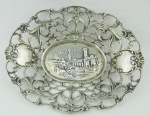 Despojador em prata européia, teor 800 milésimos, decorado com vazados flores e paisagem com castelo ao centro. Med.  15,5x12cm. Peso 85g