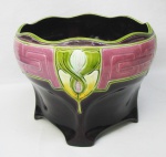 Cachepot art-noveau em faiança Tcheca, com marca da manufatura Biela, policromada e com trabalhos em relevo. Borda em ondulações. Pequena perda no esmalte de um pé. Med. 16,5x20,5 cm.
