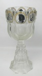 Bela e grande taça em grosso cristal europeu, com lapidações facetadas. Decorada no ápice em todo o contorno com medalhões, contendo neste pintura na cor preta com bustos diversos e instrumentos musicais. Alt. 28,5cm.
