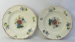 Par de pratos decorativos em faiança francesa com marca da manufatura Sarreguemines, com decoração floral em policromia. Diam. 24cm.