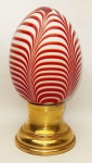 Pinha de coleção em Murano decorada internamente com frisos vermelhos e leitosos. Base em metal dourado. Alt. total 17cm.