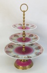 Fruteira com 3 platôs, em porcelana, decorada com diversas cenas de galanteio em policromia. Detalhes em dourado. Estrutura em bronze dourado e trabalhado. Alt. 37,5cm e Diam. prato maior 25,5cm.