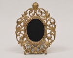 Porta retrato oval estilo barroco veneziano, em bronze patinado a ouro ricamente cinzelado e esculpido, med. 27 x 21cm.