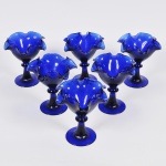 Lote composto por 06 taças para sobremesa em vidro azul com base circular e bordas onduladas. Med: 16cm