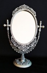 Espetacular e luxuoso espelho de bancada em metal cinzelado repleto de pedras lapidadas e contornos elegantes. Medida 19x30cm.