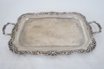 Bandeja em metal espessurado a prata, borda e alça decorada com arabescos, fundo cinzelado com flores e folhagens. Med. 50 x 29 cm. Mínimo desgaste na prateação.