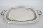 Grande Bandeja em metal espessurado a prata EBERLE, estilo inglês ao gosto Georgiano em formato ovalado, alças estilizadas, decorado com gomos circundando galeria central. Manufatura marcada no fundo. Medidas: 60 x 38cm.