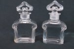 GUERLAIN, MITSOUKO. Eua de parfum.  Dois Frascos em cristal francês Baccarat   translúcido sendo seu corpo retangular moldurado superiormente por volutas à postas e tampa em formato triangular vazado. Med. 14 cm de Alt. X 9 , 5 cm de comp. Base com bicados.