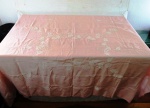 Linda toalha retangular em linho na cor rosa, com bordados  de flores no tom branco . Med. 205 x 155 cm. Mínimas manchas amarelas de guardados.