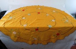 Toalha redonda em algodão na cor amarela com bordados  de flores. Med. 140 cm diâmetro. Apresenta mancha.