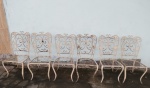 Conjunto para jardim, seis cadeiras em ferro pintado de branco, assento e encosto vazados em volutas, decoração com folhas, com douração. Pintura com desgastes. Med. 88 cm alt x 41 x 41 cm. Vendidas no estado. RETIRADA NA TIJUCA POR CONTA DO ARREMATANTE, COM AGENDAMENTO.