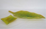 Duas (02) peças em vidro moldado ao gosto de Murano na cor verde e detalhes em amarelo, sendo um Centro de mesa no formato de folha ( 4 x 53 x 19 cm) e uma  pequena petisqueira  quadrangular ( 3 x 12 x 12 cm).