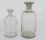 Dois antigos recipientes de farmácia em vidro translúcido. Med. maior  22,5 x 9,5 cm diâmetro. menor 17,5 x 8 cm diâmetro. Com bicado na borda.