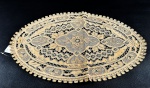 Toalha centro de mesa oval em linho na cor bege com desenhos florais, possuí manchas em razão do tempo que ficou guardada sem ser usada. Medidas aproximadas 45 cm x 31,5 cm