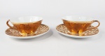 2 xícaras douradas para chá em porcelana nacional, uma das xícaras possuí pequena avaria conforme foto. Medidas aproximadas pires diâmetro 14 cm e xícara altura 5 cm e diâmetro 10 cm
