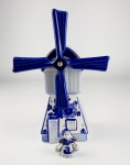 Lote contendo dois souvenirs em porcelana holandesa nas cores azul e branca sendo 1 moinho de vento musical e 1 miniatura de camponesa carregando baldes. Medidas aproximadas moinho de vento  altura 23,5 cm e largura 9,5 cm e camponesa altura 5 cm e largura 5 cm