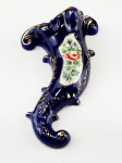 Floreira de parede em porcelana na cor azul cobalto com detalhes dourados e desenho floral  pintado a mão, possuí pequena avaria conforme foto. Medidas aproximadas comprimento 13 cm, largura 6 cm e altura 23 cm