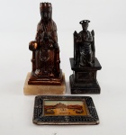 Lote contendo duas esculturas em metal  sendo uma da Virgem Montserrat e a outra de S. Pietro e  um mini porta retrato em metal com imagem de Roma. Medidas aproximadas Virgem Montserrat altura 14,5 cm, S. Pietro altura 12 cm e porta retrato 9x6,5 cm