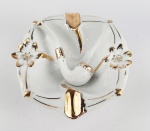 Cinzeiro em porcelana na cor branca com detalhes dourado decorado com cachimbo . Medidas aproximadas comprimento 13x12,5 cm e altura 4,5 cm.