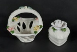 2 miniaturas em porcelana, sendo um cesta e uma caixinha decorada com flores em biscuit, possuí pequena avaria no biscuit. Medidas aproximadas cesta 8,5 x 9 cm e altura 8 cm e caixinha 4 x 5 cm e altura 6 cm