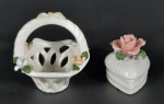 2 miniaturas em porcelana, sendo um cesta e uma caixinha decorada com flores em biscuit, possuí pequena avaria no biscuit. Medidas aproximadas cesta 8,5 x 9 cm e altura 8 cm e caixinha 4 x 5 cm e altura 6 cm