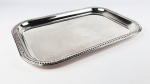 Bandeja retangular em metal espessurado a prata 90, decorada nas bordas com desenhos em alto relevo. Medidas aproximadas 44 x 30 cm