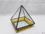 Caixa na forma de pirâmide em vidro com acabamento em metal dourado. Medindo 15cm x 15cm x 16cm de altura.
