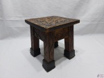 Pequena banqueta quadrada em madeira entalhada. Medindo 21cm x 21cm x 22,5cm de altura. Possui uma rachadura no assento.