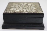 DIVERSOS - Porta jóias em madeira com tampa com placa em metal espessurado a prata decorado em relevo floral. Med. 9x19x15 cm.