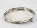 SALVA CIRCULAR EM PRATA DE LEI TEOR 833. MARCAS DO PRATEIRO SP. GALERIA VAZADA COM DECORAÇÃO VEGETALISTA. PLANO COM GUILOCHES EM ROCAILLE. ELEVADA SOBRE TRÊS PÉS EM GARRA. BRASIL, SEC. XX. 22 CM DE DIAMETRO. 360 G
