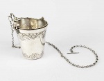 RICA GUAMPA EM PRATA DE LEI CONSTITUÍDA DE CORRENTE ATADA A COPO COM ALÇA BASCULANTE. ESSE CURIOSO OBJETO DA INDUMENTÁRIA DE CAVALEIRO ERA USADA PARA COLETAR ÁGUA ESTANDO MONTADO SOBRE O CAVALO. CORPO REMATADO POR GUILOCHES. TERMINAL DAS ALÇAS DECORADO COM FIGURAS DE GROTESCOS. BRASIL, SEC. XIX. 12 X 10 CM ( TAMANHO DO COPO CONSIDERANDO O TAMANHO DA ALÇA E DA CORRENTE).