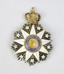 ORDEM DE NOSSA SENHORA DA CONCEIÇÃO DE VILA VIÇOSA PADROEIRA DO REINO.  GRAN CRUZ HONORÁRIA CONFERIDA A TITULAR DE TITULO DE NOBREZA.  RICA PLACA CONSTRUÍDA EM OURO, PRATA COM VERMEIL E ESMALTES. PLACA IRRADIADA SOBRE A QUAL ESTÃO APOSTAS NOVE PEQUENAS ESTRELAS BRANCAS E, ENCIMADA POR COROA REAL, ESTRELA BRANCA DE NOVE PONTAS. AO CENTRO, MEDALHÃO REDONDO COM AS LETRAS A E M ENTRELAÇADAS, EM RELEVO, CIRCUNDADO POR ORLA AZUL-FERRETE COM A LEGENDA "PADROEIRA DO REINO". ESSE EXMPLAR EM PARTICULAR É MUITO ANTIGO, O QUE SE DENOTA PRINCIPALMENTE PELO FATO DE NÃO POSSUIR MARCAS DE FABRICANTE, REMONTA PORTANTO AOS PRIMEIROS ANOS DA ORDEM.  PRIMEIRA METADE DO SEC. XIX. 9 CM DE ALTURA. 48,9 GNOTA: A ordem foi instituída pelo rei D. João VI no Rio de Janeiro em 6 de Fevereiro de 1818 para perpetuar a memória da sua aclamação como sucessor do Reino Unido, mas o alvará da ordem foi baixado apenas um ano depois, no dia 10 de setembro de 1819. Foi desenhada por JEAN-BAPTIST DREBRET. O objetivo de D. João VI, Grão-Mestre da nova Ordem Militar, era homenagear Nossa Senhora da Conceição a padroeira de Portugal, pois o país havia superado as guerras napoleônicas que tinham assolado Portugal e a Europa. EM RECONHECIMENTO E DEVOÇÃO À PADROEIRA DO REINO, TODOS OS MEMBROS DA FAMÍLIA REAL PORTUGUESA RECEBERAM A CATEGORIA DE GRÃ-CRUZES EFETIVOS. A REAL ORDEM ERA COMPOSTA POR CINCO GRAUS, ALÉM DE GRÃO-MESTRE, PRIVATIVO DO REI. OS GRAUS DECRESCENTES ERAM: AS GRÃ-CRUZES HONORÁRIAS, CONFERIDAS A PESSOAS QUE TIVESSEM TÍTULO DE NOBREZA; AS COMENDAS, AOS QUE TIVESSEM FILIAÇÃO DE FIDALGO NA CASA REAL; AS INSÍGNIAS DE CAVALEIRO.