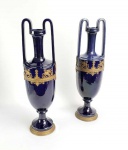 GRANDE PAR DE FLOREIROS EM PORCELANA AZUL COBALTO REMATADOS EM BRONZE. ESTILO E ÉPOCA IMPÉRIO. DECORADOS COM GUARNIÇÃO EM METAL COM FIGURAS DE ESFINGIES  COM CORPOS DE LEÃO E CABEÇAS DE MULHER. TAMBÉM BELAS ANFORAS DE ONDE BROTAM CHAMAS. UMA GREGA A TODA VOLTA COM MODELO MALMAISON. SÃO ASSENTES SOBRE PÉS TAMBÉM EM BRONZE COM RESQUÍCIOS DE ARREMATE ORMOLU. AS ALÇAS ELEVAM-SE ELEGANTEMENTE SOBRE O GARGALO. FRANÇA, SEGUNDA METADE DO SEC. XIX. 47 CM DE ALTURA (UMA DELAS TEM RESTAURO PROFISSIONAL MUITO BEM EXECUTADO)