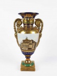 SEVRES  ESTILO E ÉPOCA NAPOLEÃO BONAPARTE  LINDA ANFORA EM PORCELANA DE SEVRES. FUNDO EM AZUL NAPOLEONICO DECORADA COM PROFUSO OURO E CENAS COM ELEMENTOS ARQUITETONICOS. TAMBÉM ESMALTES EM REMATANDO O OURO. A BASE TEM LAURÉIS RELEVADOS. ALÇAS LATEIRAIS COM FIGURA MITOLÓGICA. MARCAS DA MANUFATURA SOB A BASE. BELISSIMA PEÇA! FRANÇA, INICIO DO SEC. XIX. 36 CM DE ALTURA