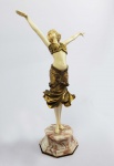 PAUL PHILIPP (1870-1930)   RADHA  EXTRAORDINÁRIA ESCULTURA CRISELEFANTINA EM BRONZE ORMULU E MARFIM SOBRE LINDA BASE EM ONIX. ASSINADA PELO ARTISTA. REPRESENTA A PERSONAGEM RADHA DO ESPETÁCULO DE MESMO NOME IDEALIZADO PELA DANÇARINA AMERICANA RUTH SAINT DENNIS. ESSE ESPETÁCULO FOI CÉLEBRE NA BROADWAY NO INICIO DO SEC. XX.  SE BASEIA NA DANÇA DE UM TEMPLO INDIANO, EXPLORANDO O DELÍRIO DOS SENTIDOS EVOCADO ATRAVÉS DE EXÓTICOS TRAJES E CENOGRAFIA (VEJA NOS CRÉDITOS EXTRAS DESSE LOTE  FOTO DE RUTH SAINT DENNIS CARACTERIZADA COMO RADHA EM SEU ESPETÁCULO). PAUL PHILIPPE CONCEBEU UMA DANÇARINA EXÓTICA VESTIDA COM SUAS ROUPAS E ACESSÓRIOS. O MOVIMENTO DE SUA SAIA CONFERE GRANDE DINAMISMO A ESTE TRABALHO.  DUAS VERSÕES DESTA ESCULTURA FORAM EXIBIDAS NO GORHAM GALERIA DE NOVA YORK EM 1914 (UMA EM BRONZE E MARFIM E OUTRA SOMENTE EM BRONZE). UM EXEMPLAR DA RADHA DE PAUL PHILIPP FOI ARREMATADO RECENTEMENTE EM LEILÃO DA CASA CHRISTIES EM LONDRES POR 33600 LIBRAS (VIDE EM : HTTPS://WWW.CHRISTIES.COM/LOTFINDER/LOT/PAUL-PHILIPPE-RADHA-SCULPTURE-CIRCA-1925-4901750-DETAILS.ASPXA OBRA ESTÁ REPRODUZIDA NA PÁGINA 262 DO LIVRO ART DECO AND OTHER FIGURES BY BRYAN CATLEY, PAG. 262. FRANÇA, CIRCA DE 1915.  35 CM DE ALTURANOTA: Ruth Saint Denis (20 de janeiro de 1879  21 de julho de 1968) foi bailarina e coreógrafa,  nascida em New Jersey e criada em uma fazenda por seu pai, mecânico desempregado e sua mãe, que tinha um diploma de medicina. Esse fato fez com que ela entrasse em contato com movimentos filosóficos e religiosos. Por morar em uma fazenda, Ruth desenvolveu desde pequena sua fascinação pelos elementos da natureza, despertando assim seu interesse pelos aspectos espirituais da mãe natureza. Ruth Saint Denis pode ser considerada a pioneira da dança moderna americana, se destacou por suas apresentações orientais e pelo seu interesse pelo exotismo, misticismo e a espiritualidade presente em seus estudos. Em suas coreografias misturava os conceitos do físico e da divindade, isso fez com que ela estudasse inúmeras religiões ao longo de sua vida. Para ela a dança era um ritual e uma prática espiritual.  Em 1898, Ruth é descoberta por David Belasco, produtor da Broadway bem sucedido que a contrata para ser bailarina de sua empresa de grande porte.  Em 1904 em uma de suas viagens com Belasco, ela observa em um outdoor de propaganda de cigarros, a imagem da Deusa Egípcia do amor e da magia, com o nome de Ísis. Esse fato fez despertar seu interesse sobre o Egito e a Índia. A partir disso Ruth criou sua coreografia chamada Radha, que foi apresentada até seus 80 anos de idade. PAUL PHILIPP - Philippe nasceu na França por volta de 1870. Ele estudou na École des Beaux-Arts em Paris, França, sob a direção de Antonin Larroux (18591913). Ele se especializou em esculturas de bronze e criselefantina que apresentavam mulheres jovens. Várias das peças que ele criou eram de figuras nuas, o que era popular durante a época em que ele trabalhou. Ele trabalhou por um tempo em Berlim , às vezes empregando as fundições Rosenthal und Maeder (RUM) e Preiss -Kassler  para fundir O trabalho dele. Philippe é talvez mais conhecido por sua escultura de cerca de 1925 intitulada Awakening , embora sua obra consista em um grande corpo de trabalho.  Awakening apresenta uma jovem mulher nua se espreguiçando ao acordar de uma longa noite de sono. O trabalho de Philippe está exposto no Museu de Arte Deco , em Moscou , na Rússia , um dos mais novos museus da cidade, que foi inaugurado em 2014.Seu trabalho também é uma parte de outras coleções importantes e muitas vezes aparece para venda em grandes casas de leilão em todo o mundo, às vezes vendendo por quantias pesadas.