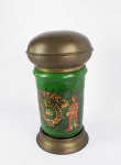 TOBBACO JAR  JARRO DE FUMO DE TABACARIA. GRANDE JARRO PARA FUMO EM FAIANÇA POLICROMADA COM GUARNIÇÕES EM METAL. POSSUI A MARCA TOBACCO SWEET RETURNS (DOCE RETORNO) E O SÍMBOLO DE UM VELEIRO ENTRE FOLHAS DE FUMO ALADO POR UM INDIO SUL AMERICANO E UM ÁRABE FUMANDO EM GRANDE CAXIMBO.  FUNDO NA TONALIDADE VERDE. HOLANDA, INICIO DO SEC. XX. 37 CM DE ALTURA