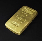 PESO DE PAPEL COM FORMATO DE BARRA DE OURO. COM MARCAS DO CREDIT SUISSE. AS INCRIÇÕES 500G GOLD 999,9 E A NUMERAÇÃO. 13 CM DE COMPRIMENTO
