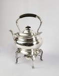 PRATA DE LEI INGLESA- TEA KETTLE EM PRATA DE LEI COM MARCAS PARA CIDADE DE SHEFFIELD, LETRA DATA PARA O INICIO DO SEC. XX E PRATEIRO GEORGE HAPE. ELEGANTE ESTRUTURA COM CORPO LISO E EXTREMIDADES DECORADAS COM GODRONS. INGLATERRA, INICIO DO SEC. XX. 32 CM DE ALTURA. 1350 G