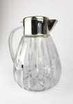 GRANDE JARRA COM REFRESCADOR EM CRISTAL LAPIDADO EM SULCOS E CÍRCULOS COME GUARNIÇÃO EM METAL ESPESSURADO A PRATA. POSSUI RERESCADOR ACOPLADO PARA ADIÇÃO DE GELO SEM QUE ESTE SE MISTURE AO CONTEÚDO DA JARRA APÓS O DERRETIMENTO. EXCELENTE ESTADO DE CONSERVAÇÃO! ALEMANHA ORIENTAL, MEADOS DO SEC. XX. 26 X 20 CM.