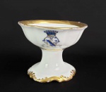 CONDE DE BAEPENDI  (1812-1887)   BRÁS CARNEIRO NOGUEIRA DA COSTA E GAMA SALEIRO DE MESA EM PORCELANA DO SERVIÇO DO SEGUNDO CONDE DE BAEPENDI, BRÁS CARNEIRO NOGUEIRA DA COSTA E GAMA .  ERA FILHO DO MARQUÊS DE BAEPENDI E TINHA COMO IRMÃOS O BARÃO JUPARANÃ E O BARÃO DE SANTA MONICA. ERA GENRO DO CONDE DE CARAPEBUS E SEU FILHO CASOU COM UMA DAS FILHAS DOS BARÕES DE CARAPEBUS. A LOUÇA É DA  MANUFATURA CF DE CHRISTIAN FISCHER, DA BOHEMIA EMPREGADAS ENTRE 1846 E 1860. BORDA TIOTADA REALÇADA EM OURO E ROSA EM TOM BLUSHING. NA BORDA MONOGRAMA COM INICIAIS NGC ENTRELAÇADAS EM AZUL REALÇADAS EM OURO SOB COROA DE CONDE. O SEGUNDO CONDE DE BAEPENDI TEVE DESTACADA IMPORTÂNCIA NA POLITICA BRASILEIRA, FOI POR VÁRIAS  OCASIÕES PRESIDENTE DA CÂMARA E DO SENADO DO IMPÉRIO. TINHA PARENTESCO NA CIDADE DE CAMPINAS , ERA PRIMO DO PRIMEIRO PÁROCO DA CIDADE  DE CAMPINAS FREI ANTÔNIO DE PÁDUA TEIXEIRA E DO FUNDADOR DA CIDADE FRANCISCO BARRETO LEME.  O MUI NOBRE CONDE DE BAEPENDI RECEBEU OS TÍTULOS DE GENTIL-HOMEM DA IMPERIAL CÂMARA; FIDALGO CAVALEIRO DA CASA IMPERIAL; VISCONDE COM GRANDEZA, PELO DECRETO DE 12 DE OUTUBRO DE 1828; CONDE DE BAEPENDI, PELO DECRETO DE 2 DE DEZEMBRO DE 1858. 8,5  CM DE DIAMETRO