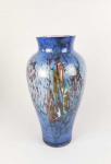 MARIO SEGUSO  BELO FLOREIRO EM VIDRO ARTÍSTICO DE MURANO COM FUNDO NA TONALIZADE AZUL E NUANCES EM AMARELO E ROSE. ASSINADO M SEGUSO E DATADO 1998. 34 CM DE ALTURANOTA: Mario Seguso, nascido em Murano (Veneza-Itália), em 1929, descende de uma das mais antigas e famosas famílias ligadas ao vidro, existentes em Murano, desde antes do ano de 1300. Após concluído o curso de 1º grau em Murano, no ano de 1941 passa a estudar no Regio Istituto dArte, de Veneza, dedicando-se ao ramo de Gravação sobre Cristal sob a guia artística dos professores Guido Balsamo Stella e Carlo Scarpa, e dos técnicos Eliseo Piano e Franz Pelzel. Cursa naquele período também outras modalidades artísticas, assim como Desenho e Formas para serem executadas nas fábricas de cristal. Frequenta todas as aulas de Glittica, gravação de armas, brasões e figuras sobre pedras duras e semi-preciosas. Contemporaneamente aos cursos que frequenta no Instituto de Arte, nos anos de 1947-1948 faz estágio no atelier S.A.L.I.R., de Murano, onde começa a aprimorar os ensinamentos recebidos e executa os seus primeiros trabalhos de forma profissional. De 1949 até maio de 1954, abre seu próprio atelier, em Murano, onde executa suas gravações para as mais conceituadas empresas especializadas no comércio do cristal artístico, como Salviati, Gino Cenedese, Fischer, fornecendo peças encomendadas especialmente para exportação, como também taças e troféus para importantes eventos e competições. Participa, durante este período, de várias exposições, destacando-se entre elas aquela realizada na Galleria Bevilacqua La Masa, em Veneza. Em 1953 executa, com desenho de Oscar Kokoschka, uma gravação para a Mostra Internazionale promovida pelo Centro do Vidro Moderno de Murano, que tinha sido fundado naquela época. Em 1954, a convite da Cristais Prado S.A.  com sede na cidade de São Paulo  transfere-se para o Brasil, onde grava uma série de peças (taças e vasos) apresentadas na Grande Exposição Comemorativa dos 400 Anos da Fundação de São Paulo, realizada no Parque Ibirapuera. De 1954 a 1956  sempre para a Cristais Prado S.A.  executa vários trabalhos, entre os quais os enviados à Exposição Mundial de Bruxelas, na Bélgica, e os destinados a diversos compradores dos Estados Unidos e do Canadá. É deste período a grande taça alegórica gravada para presentear o Presidente da República, Juscelino Kubitschek de Oliveira. No ano de 1956 desliga-se da Cristais Prado para montar seu atelier, onde trabalha por conta própria e dá assistência a uma cristaleria de São Paulo, na qualidade de designer. Dedica-se a novas pesquisas sobre a técnica de gravação, substituindo uma parte do que adquirira através do aprendizado tradicional por uma maior aproximação à realidade da cultura brasileira, levando-a a uma interpretação mais moderna de sua arte primitiva, transmitida por rápidos e decididos entalhes. Desenvolve neste período o estilo que será o ponto de partida de toda sua futura produção artística. Para poder ter cristais em quantidade e qualidade necessárias para gravar, no ano de 1965 funda, com dois sócios também de tradicionais famílias vidreiras de Murano  Vittorio Ferro e Piero Toso  a Cristaleria Artística Cá dOro, em Poços de Caldas, para a qual desenha a maior parte das peças produzidas seguindo um estilo sóbrio e moderno. Poucos anos após a fundação da fábrica, Vittorio desliga-se para voltar à Itália e 10 anos mais tarde Piero se aposenta. Dentro da própria fábrica, Mario cria a Oficina de Fogo e Arte, para dar continuidade às pesquisas de novas formas e efeitos. Com o domínio absoluto da refinada técnica de desenho e fabricação, aliado a todos esses anos de absorção da cultura, flora, fauna, luzes e outras maravilhas brasileiras, Mario revela seu estilo inconfundível sempre criando novas peças e esculturas. O seu trabalho artístico passa a ser amplamente reconhecido no Brasil e no exterior. Em uma contínua pesquisa de novas formas e efeitos, Mario Seguso desenvolve, há muitos anos, seu trabalho na Oficina de Fogo e Arte por ele fundada. Dentro da filosofia européia, na qual foi educado, Mario Seguso esquiva-se das improvisações e modismos passageiros, entendendo que o objeto criado deve, por si mesmo, afirmar-se e ser julgado após uma séria análise sobre as características técnicas e artísticas nele contidas, análise esta compreendida somente por quem possua um sólido conhecimento, não só da parte artística, mas também das limitações e dos mistérios que o vidro oferece. Foram necessários muitos anos de expectativa para se ver realizar a metamorfose inciada desde sua chegada ao Brasil. No ano de 1992, por ter alcançado um estágio de consciente amadurecimento, decide apresentar suas obras elaboradas durante anos de contínuas pesquisas e experiências vividas ao calor das fornalhas, manipulando e plasmando o mais nobre e exigente dos materiais. O lento abandono dos vínculos que o ligavam aos padrões e tradições européias deixavam espaço para a mudança, que ocorria a medida que intensificava sua convivência e participação da vida, cultura e tradições do Brasil. As únicas coisas mantidas e respeitadas neste longo processo foram à técnica, trazidas da Europa e a fidelidade a uma tradição de muitos séculos de vidro e arte vividos em Murano pela família Seguso. A demora em apresentar seus trabalhos únicos e assinados para a apreciação do público e da crítica deveu-se somente ao período de tempo que se tornou necessário para adquirir a certeza de apresentar obras idealizadas e plasmadas, para serem verdadeiros frutos da terra brasileira e da sua cultura, iniciando assim, no setor da arte de vidro artístico, o desvencilhamento dos modelos vindos de fora, para começar uma escola e um estilo próprio.