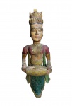 REINO DE RAJASTHAN  ARREMATE DE BALCÃO DE PÁTIO DE HAVELI DA CIDADE DE MANDAWA. MUSICISTA (TOCADORA DE MRIDANGAM QUE É UM INSTRUMENTO DE PERCUSSÃO DA ÍNDIA, ESPECIALMENTE DO SUL. O INSTRUMENTO É CONHECIDO COMO "DEVA VAADYAM", OU "INSTRUMENTO DOS DEUSES") COMPÕE UM GRUPO DE QUATRO ESCULTURAS UTILIZADAS COMO ARREMATE E DECORAÇÃO DE BALCÃO NO PÁTIO PRINCIPAL DE UM HAVELI (PALÁCIO CONSTRUÍDO PELOS COMERCIANTES ENRIQUECIDOS PELO COMÉRCIO DA ROTA DA SEDA). A GRANDE ESCULTURA COM AS OUTRAS TRÊS QUE ACOMPANHAM O LOTE, FEZ AS VEZES DE MÃO FRANCESA SOB BALCÃO COM VISTA PARA O PÁTIO DOS HOMENS DE UM HAVELI. ALI ERAM PERMITIDAS AS MULHERES ENQUANTO OS HOMENS ESTAVAM REUNIDOS NO PÁTIO. ESSA FLAUTISTA COM LINDAS CORES ORIGINAIS, É APRESENTADA COM UM SARI DE FESTA CINGINDO COROA SOB LINDOS CABELOS ENRODILHADOS, AS COROAS INCLUÍDAS NA SUNTUOSA DECORAÇÃO DOS HAVELIS MANIFESTAM A COBIÇADA NOBREZA ALMEJADA POR SEUS RICOS PROPRIETÁRIOS. RAJASTHAN, INICIO DO SEC. XIX. 115 CM DE ALTURANOTA: Havelis eram Casas suntuosas construídas em um estilo arquitetônico único no século 18 e no início do século 19, e que já foram propriedade de comerciantes ricos. Foram construídos na região de Shekhawati, onde fica a cidade de Mandawa. Os havelis do Rajastão foram construídos pela rica comunidade Marwari na região de Shekhawati, no Rajastão, no século XIX. Um haveli normalmente tem dois pátios, um para os homens e o interno para as mulheres, as paredes eram adornadas com belos afrescos coloridos pintados por artistas contratados. Com o desenvolvimento de grandes cidades como Calcutá e Mumbai, desviando o comércio trans-Thar para o sul e para o leste, a importância dos postos comerciais de Shekhawati declinou rapidamente e as mansões pintadas dos mercadores não foram mais cuidadas. Abandonada pelos proprietários, que migraram para as cidades em busca de pastagens mais verdes, a maior parte de Shekhawati havelis, incluindo Mandawa, estava completamente abandonada e, atualmente, os antigos postos avançados da rota comercial se assemelham a cidades fantasmas. Mandawa, apesar de ser uma das cidades Shekhawati mais bem conservadas, mostrou grande negligência, e o pequeno principado feudal localizado remotamente manteve muitas mansões pintadas notáveis. Os mais famosos eram o Hanuman Prasad Goenka Haveli, o Goenka Double Haveli, o Murmuria Haveli, o Gulab Rai Ladia Haveli, etc e havia também o forte que ocupava o centro da cidade. Os  ricos  afrescos de Mandawa, que foram encomendados pelos proprietários dos Havelis, exibiam suas sensibilidades culturais, crenças religiosas, aspirações reais e flagrante confronto com o poder britânico. Embora os mercadores fossem tão ricos quanto os governantes Rajput, a hierarquia social estrita os proibia de construir palácios e fortes tão grandes quanto os da realeza. Então, eles se concentraram nos interiores e se deleitaram em conseguir que fossem decorados primorosamente com cores feitas de ouro, prata e outras pedras preciosas. O declínio da riqueza das famílias dos proprietários, enormes custos de manutenção e zero esforços do governo para proteger as mansões fizeram de Shekhawati um patrimônio que morria rapidamente e com a falta de manutenção no século XX quase todos os Havelis foram desmantelados.