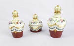 SEVRES  CONJUNTO DE BOUDOIR EM PORCELANA COM DOIS FRASCOS PARA ÁGUA DE COLÔNIA E UM POTE. MARCAS DA MANUFATURA DE SEVRES. TERÇO INFERIOR NA TONALIDADE ROUGE DE FEUR SUCEDIDO POR LAURÉU, LOGO APÓS RELEVO DE GUIRLANDA ENCIMADO POR FLORES PINTADAS EM ESMALTE. AS PEGAS NAS TAMPAS SÃO EM FEITIO DE COROAS. ARREMATES EM OURO.  FRANÇA, FINAL DO SEC. XIX. 18 CM DE ALTURA.