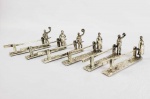 WMF  - FORMIDÁVEL  CONJUNTO COM SEIS DESCANSOS DE TALHERES EM METAL ESPESSURADO A PRATA. A DECORAÇÃO É BELISSIMA COM FEITIO DE CERCA ONDE SE RECOSTA UM HOMEM CUMPRIMENTANDO COM SEU CHAPÉU E UMA MULHER TAMBÉM RECOSTADA EM CERCA QUE CUMPRIMENTA COM SEU VESTIDO. UM MODELO EXTREMAMENTE RARO, ROBUSTO E MUITO BONITO. ALEMANHA, SEC. XX 13 CM DE COMPRIMENTO.